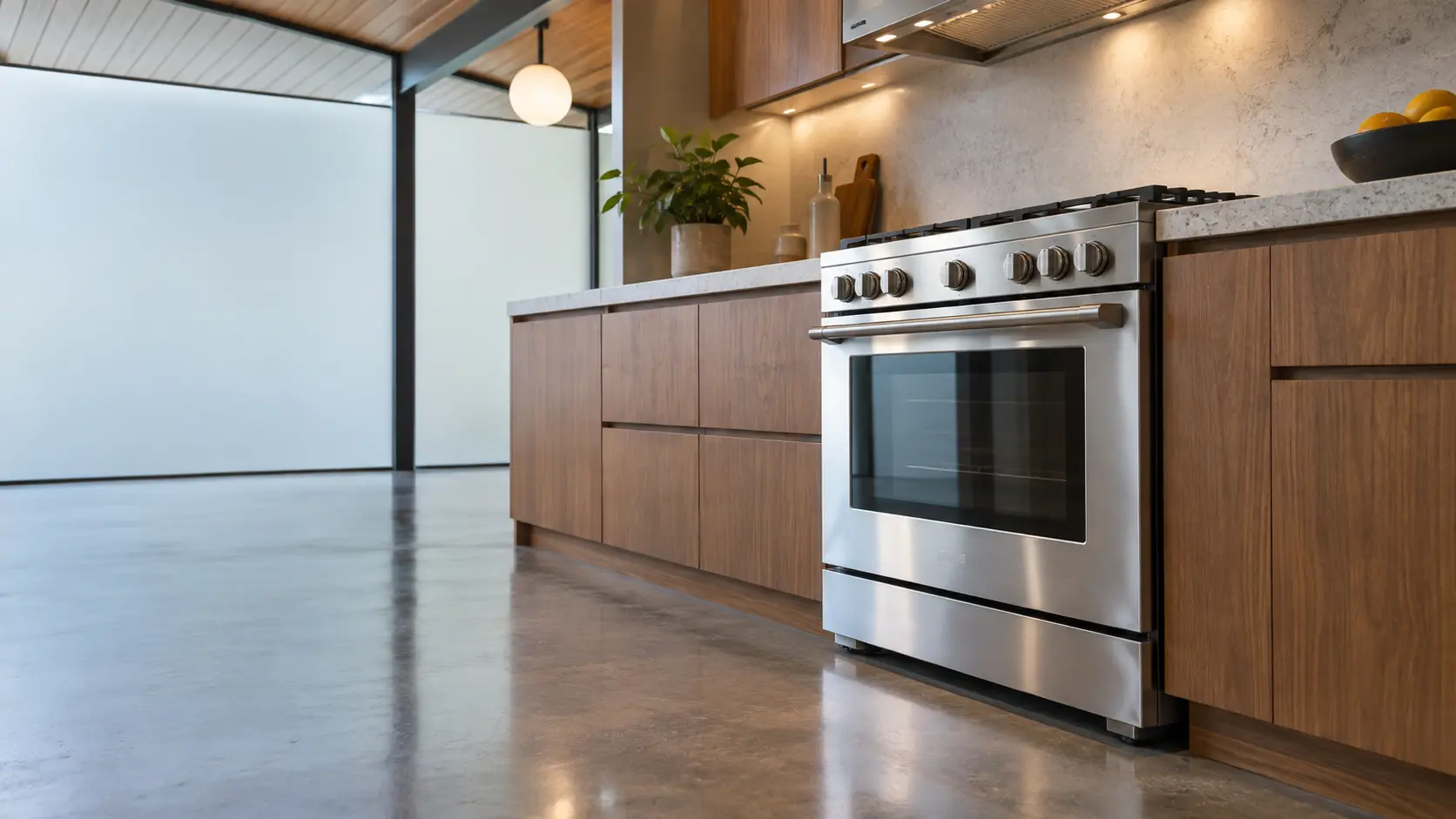 A kitchen with the range in an Eichler house kitchen with a range in a glass-walled kitchen, seen from a low angle, the oven door glass catching the light.